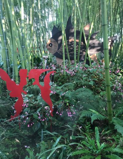 Bamboo garden with sculpture of fish in Italy