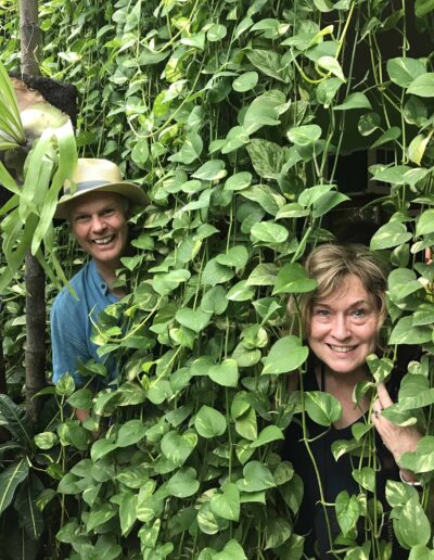 Charlie and Deb standing in Wall of green Pothos plants