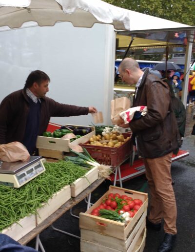 Farmers Market in Loire Valley, France. Man buying vegetables