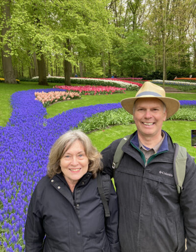 Charlie and Deb at Keukenhof Gardens, Holland under trees with colorful tulip beds